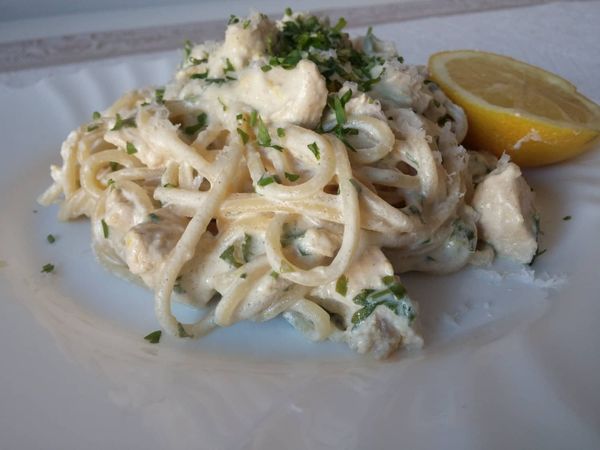 Spaghetti con salsa de limón, crema y perejil con chips de pollo